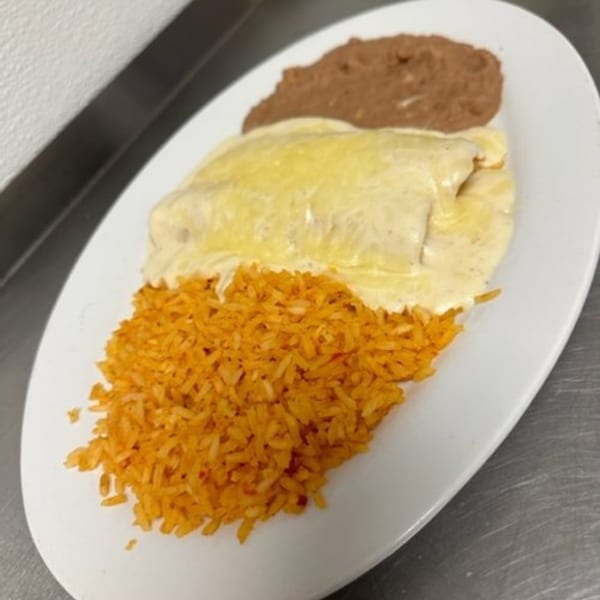 Los Charros' enchilada plate with creamy white sauce, orange rice, and refried beans.