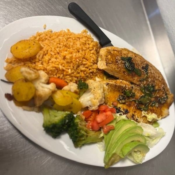 Los Charros' Mexican dish with grilled fish, rice, roasted vegetables, avocado, and diced tomatoes.