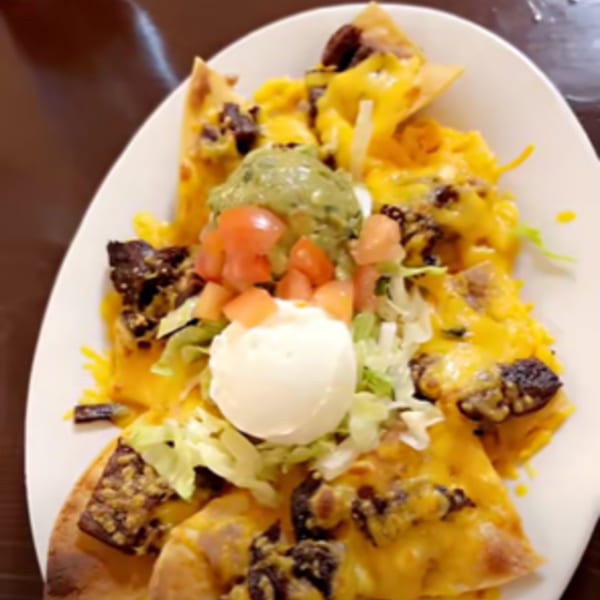 Los Charros nachos with melted cheese, beef, guacamole, sour cream, and diced tomatoes.