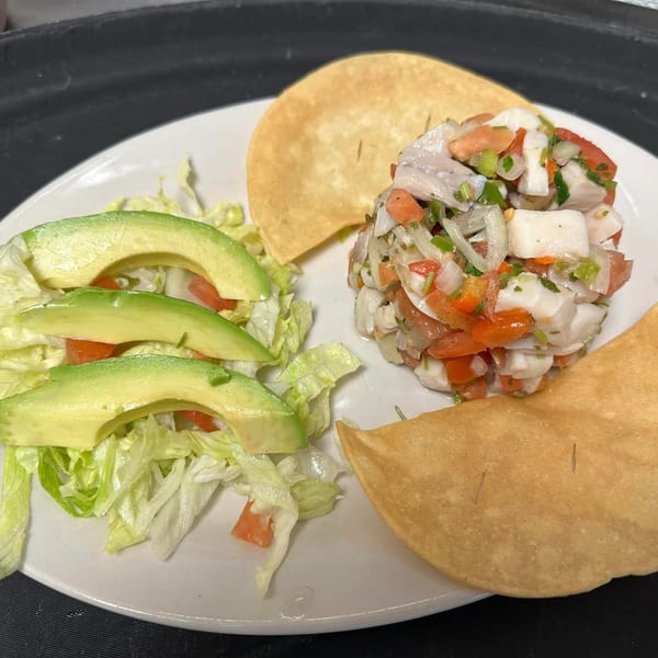 Los Charros' ceviche with diced fish, tomatoes, onions, cilantro, avocado, lettuce, and tostadas.